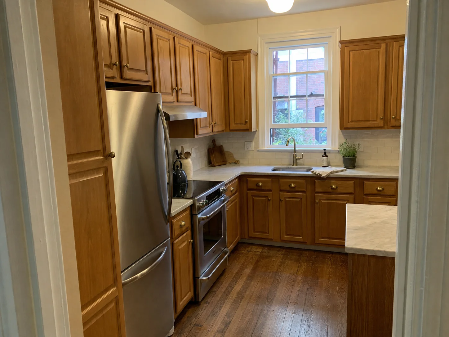Honey oak kitchen cabinets before cabinet painting in a Georgetown, Washington DC home